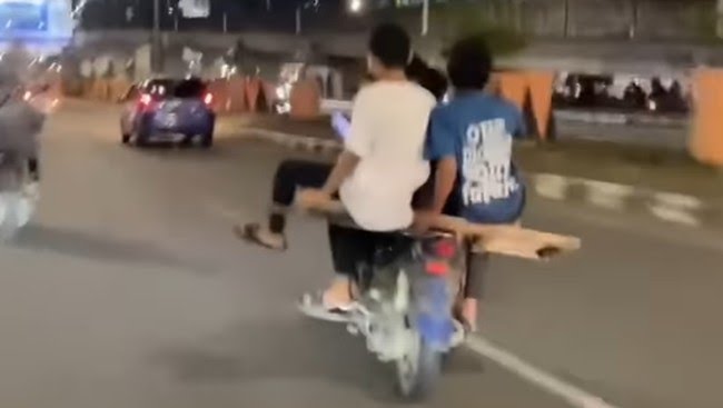 remaja berkendara motor dengan cara berbahaya di jalan raya