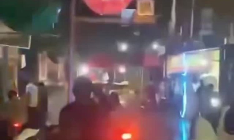  petugas kepolisian sedang melerai kerusuhan di jalanan