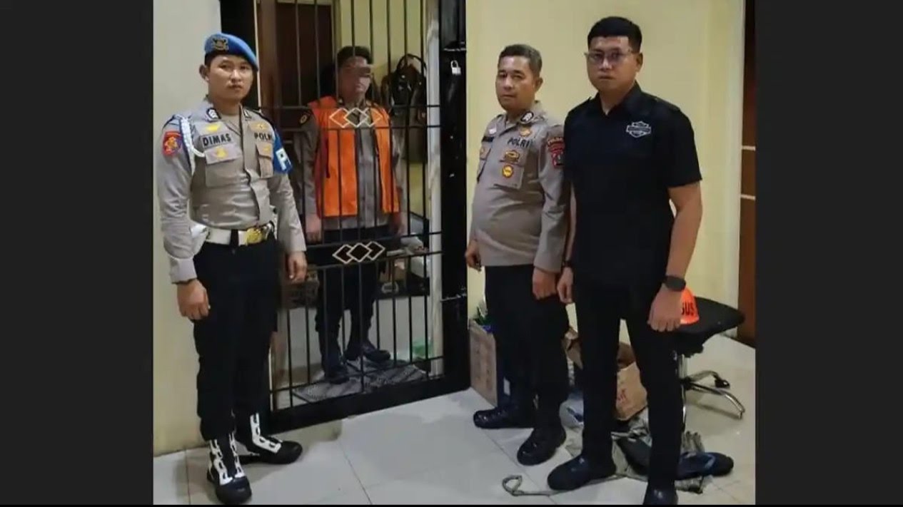 Kompol DK mengenakan rompi orange dari balik jeruji besi